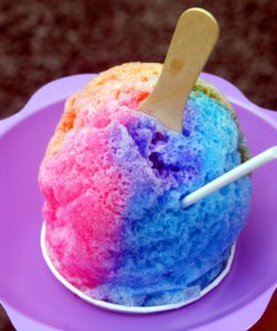 a rainbow sno-cone in a purple cup