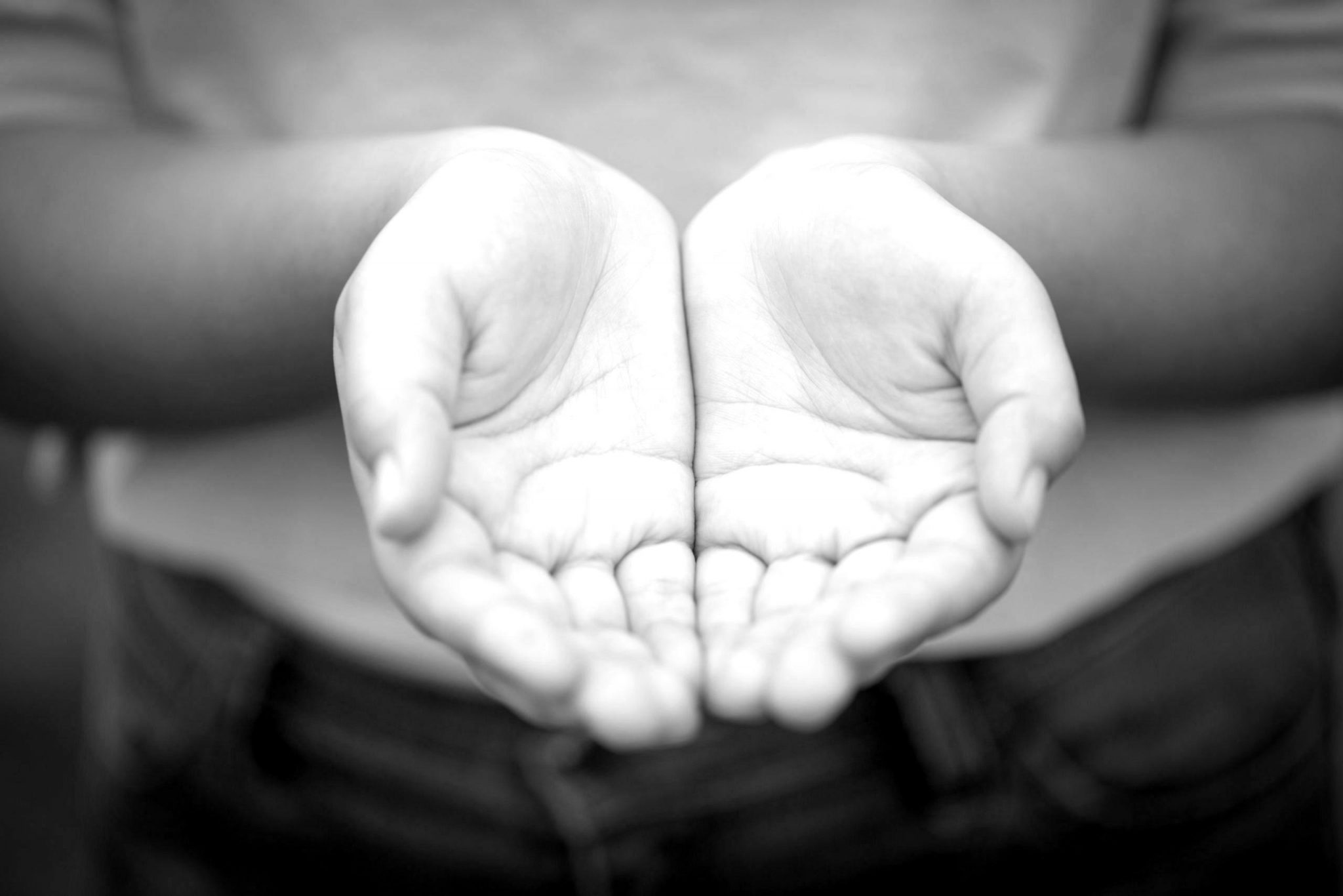 a black and white photo of two open hands cupped together, symbolizing the acceptance of fear in motherhood