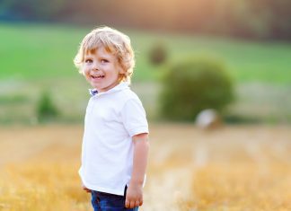 a blonde toddler boy in a wheat field