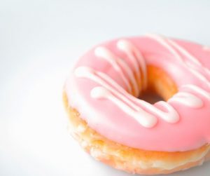 a pink iced donut on a white background