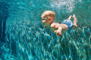 a baby floating underwater in a pool