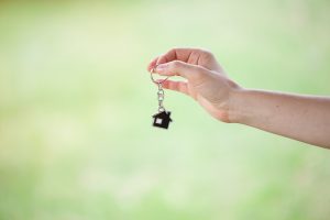a close-up of a hand holding a house shaped key chain
