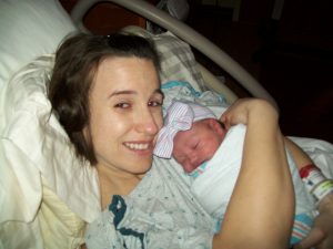 a mom holding her newborn daughter after a natural birth at the hospital