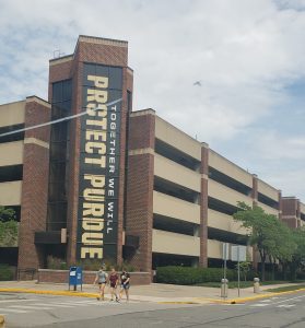 a building on the Purdue college campus with a giant sign stating,Together We Will Protect Purdue