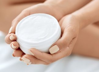 clean beauty hand lotion in an open jar in the hands of a woman