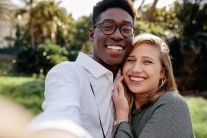 an interracial couple taking a selfie