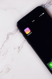 a smartphone with an Instagram app icon on a marble countertop
