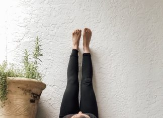 a woman laying on the floor with her feet up against the wall to relax and handle stress