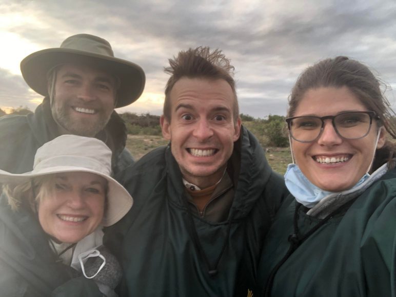 four adults smiling for the camera on an African safari