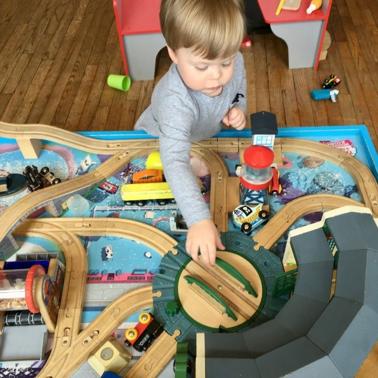 a toddler boy playing with a train table at the Frisco Train Store in St. Louis, Missouri