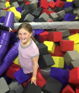 a girl playing in the foam block pit at Defy in St. Louis, MO