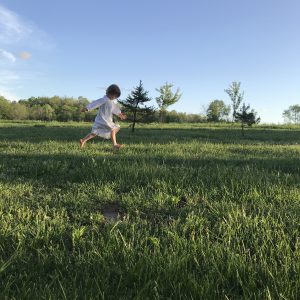 a girl running through the grass