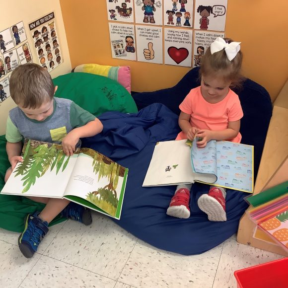 kindergarten kids reading in a reading nook at Kiddie Academy in St. Louis