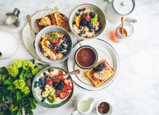 a breakfast spread on white dishes on a white tablecloth