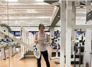 a woman standing in front of a mirror at a Lifetime Fitness gym
