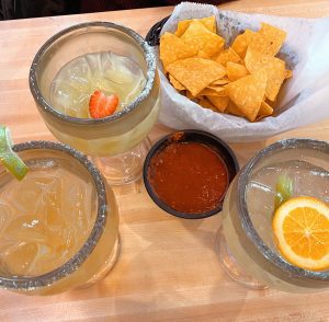 margaritas on a table with a basket of chips with salsa for a mom’s night out