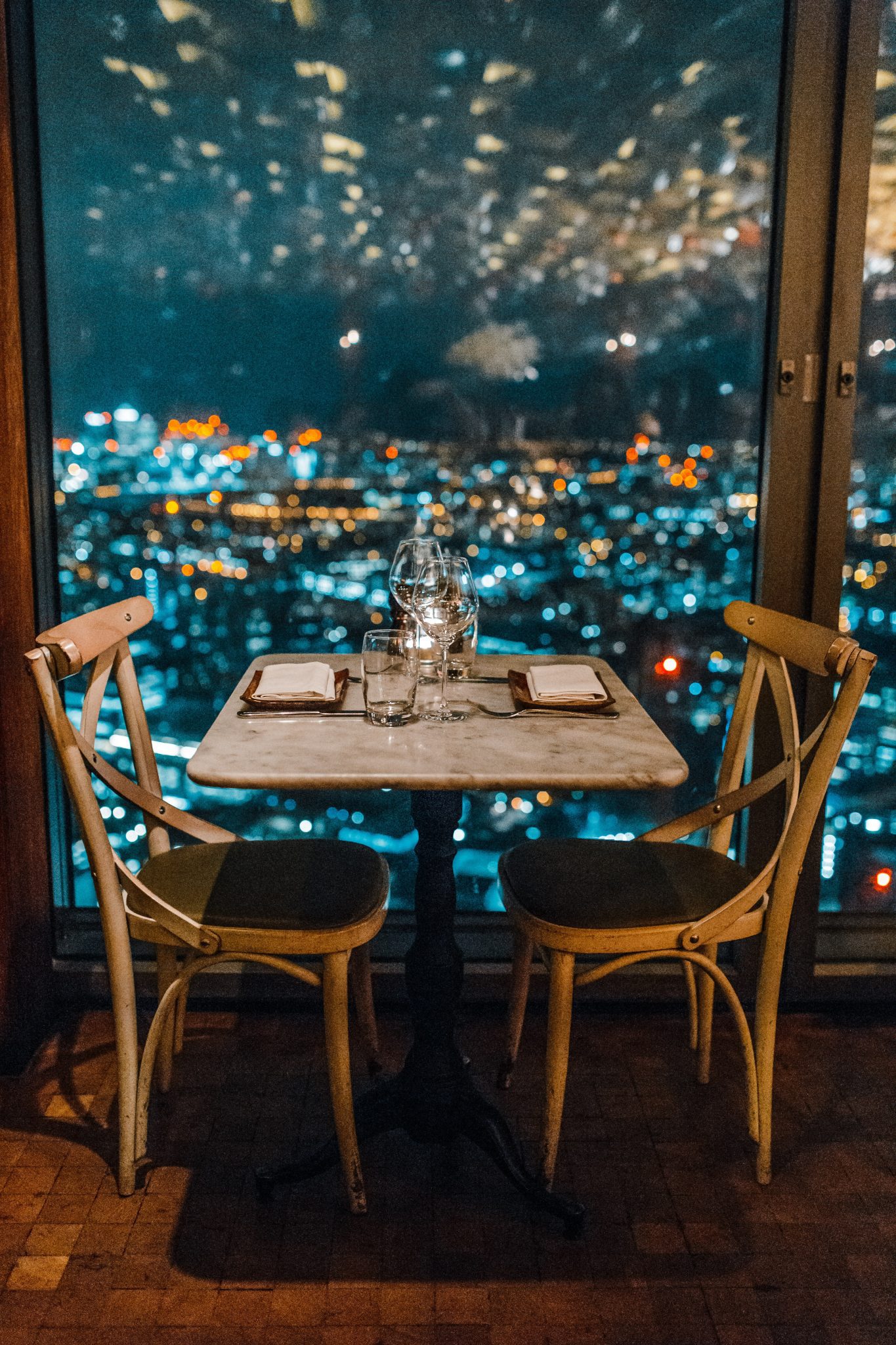 a table for two set by a window overlooking a city for a special date night out
