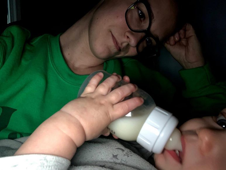 a mom staring at her baby as he drinks from a bottle