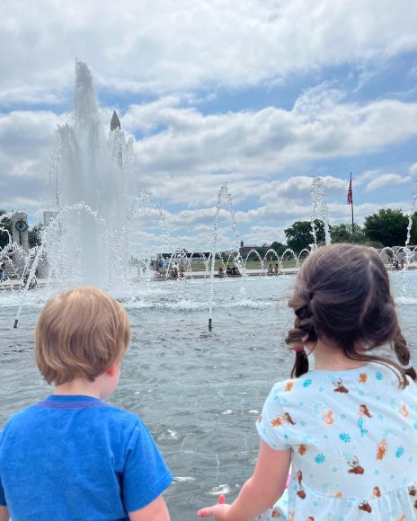 a young boy and girl holding hands by the fountains in Washington, DC as they took the trip to visit there