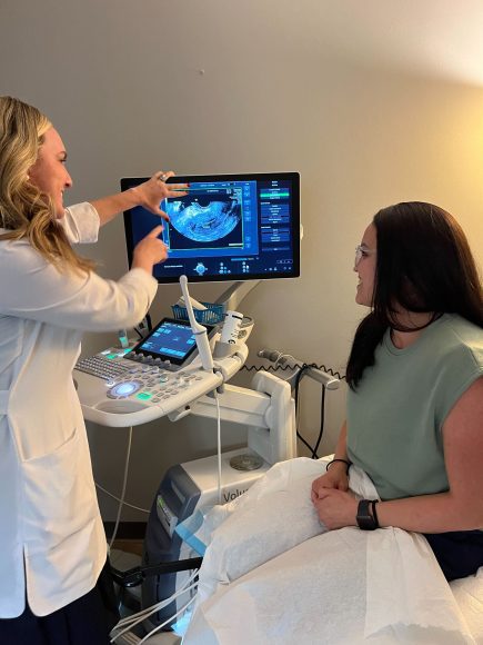 a doctor showing an ultrasound image to an infertility patient regarding secondary infertility