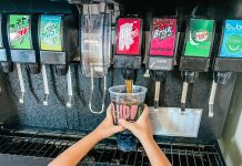 a young boy fostering independence by filling his own cup at the soda machine