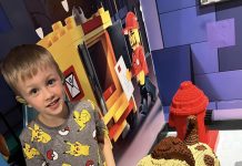 a young boy standing next to a Lego dog and fire hydrant at LegoLand in Kansas City