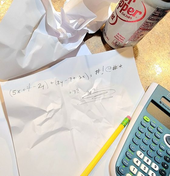 a crumpled paper with math equations written on it alongside a pencil, calculator, and can of diet soda representing the nightmares of math homework