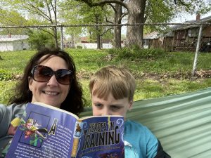 Josh and I reading Heroes in Training in our backyard hammock.