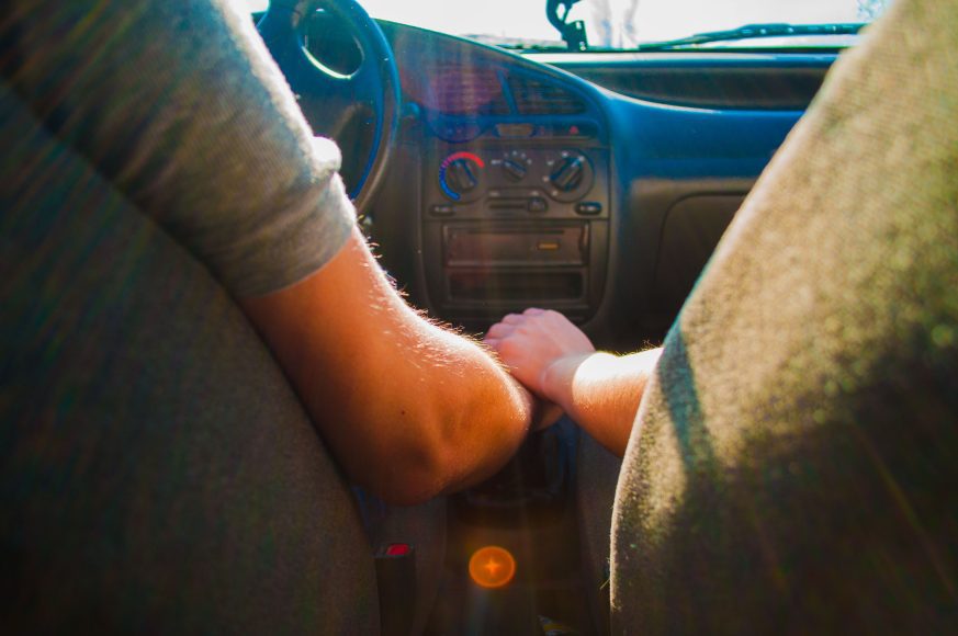 a couple holding hands in the car