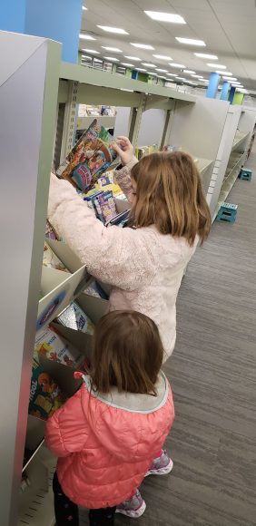 two girls choosing books at a library