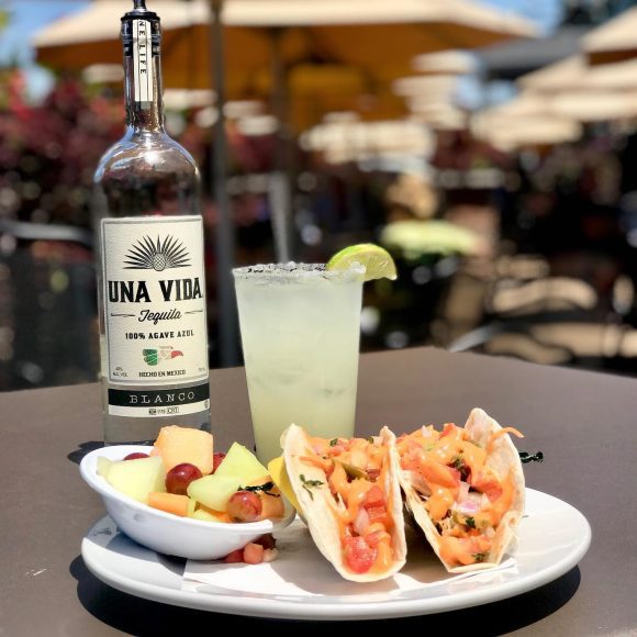 tacos and tequila on an outdoor patio table