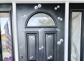 a black door with google eyes affixed to it for Halloween decorations