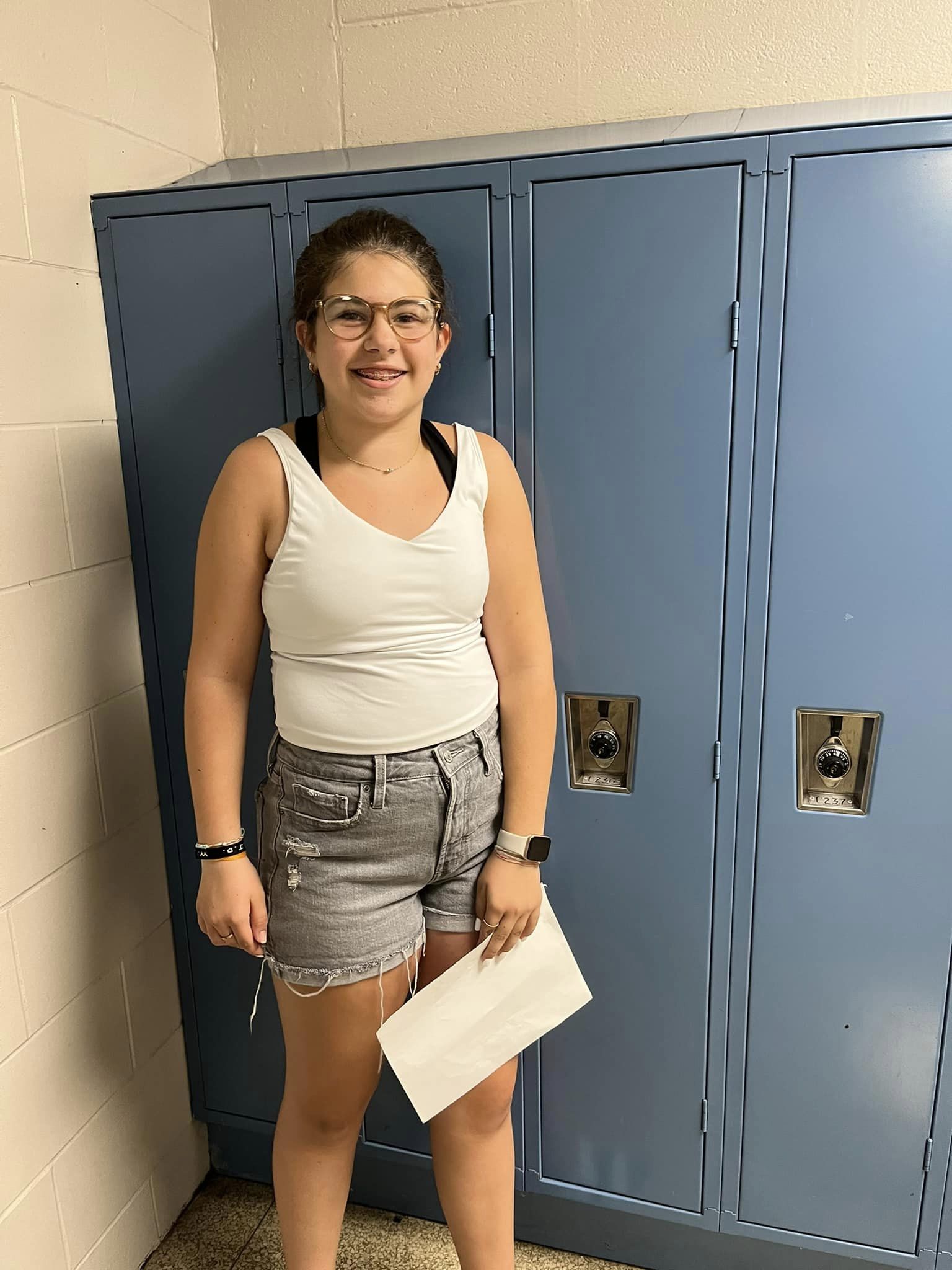 a girl standing in front of her middle school locker