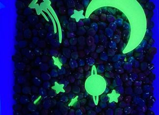 a sensory bin with chick peas and glow in the dark stars and planets under a UV light