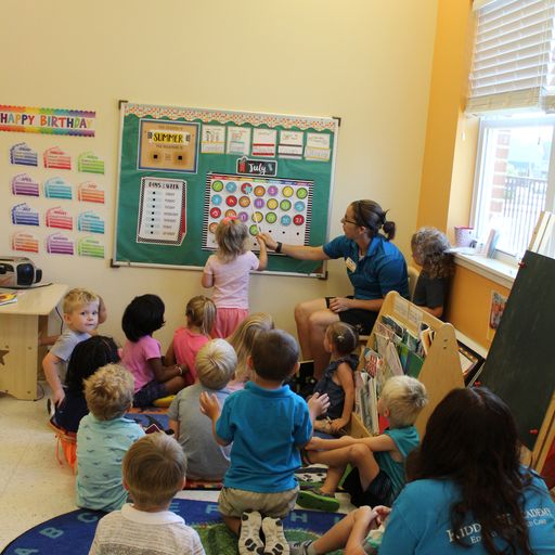 a teacher leading a group of kids in circle time at a Kiddie Academy in St. Louis, MO