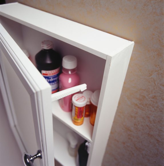 a partially open medicine cabinet with a child safety lock