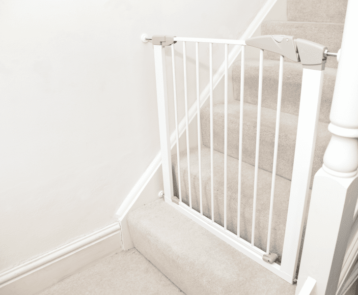 a baby gate at the bottom of stairs