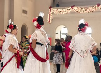 women in cultural holiday dress with flowers in their hair at Winter Celebrations at the St. Louis Art Museum